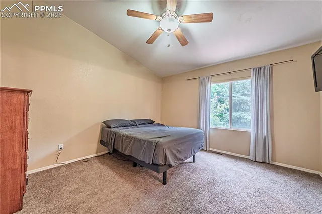 a spacious bedroom with a bed and a chandelier