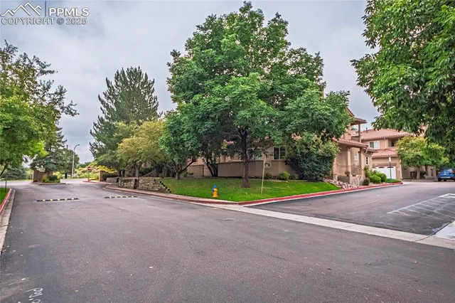 a view of a street with houses and trees in the background