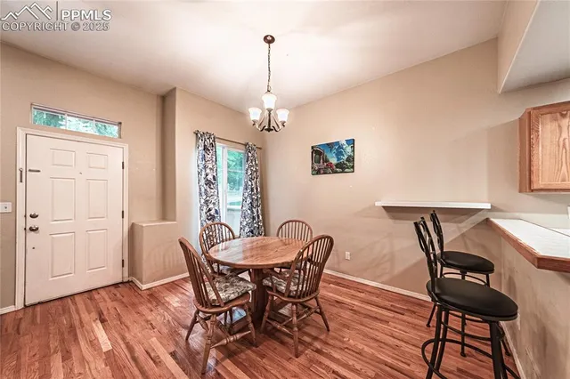 a dining room with furniture a chandelier and wooden floor