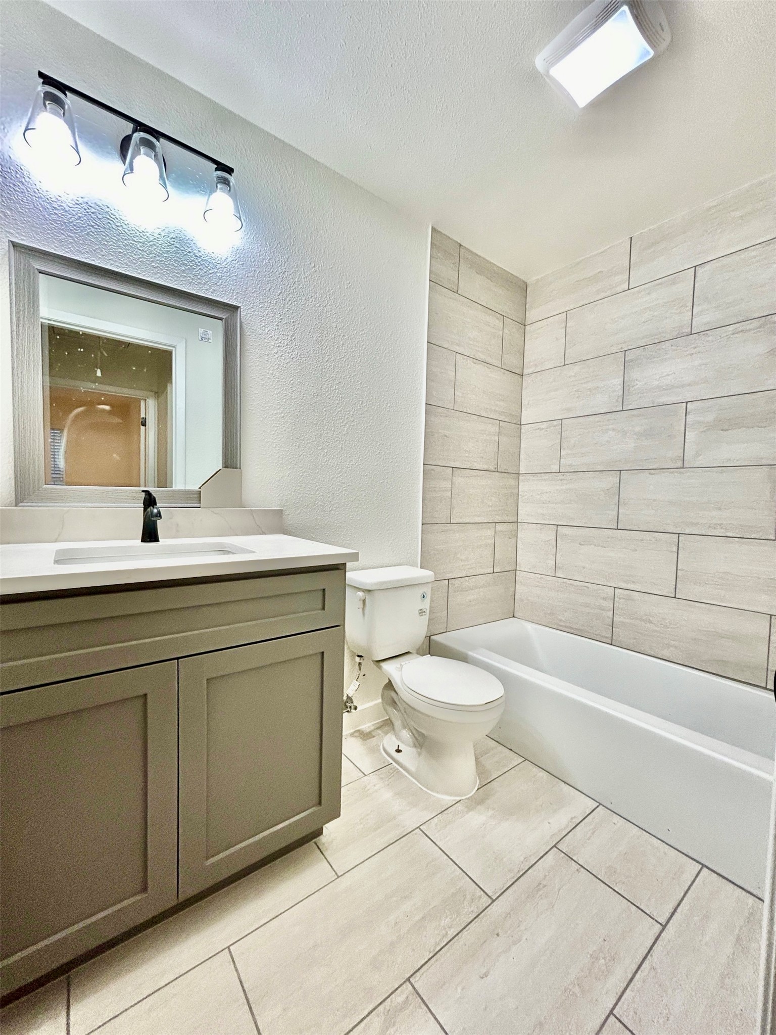 5903 Cougar Drive, Unit C Austin, TX 78745 - Photo 3 of 16 Bathroom with a textured ceiling, vanity, a textured wall, and shower / washtub combination