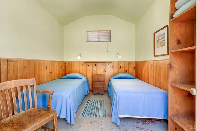 a view of a white house with wooden fence and sitting area