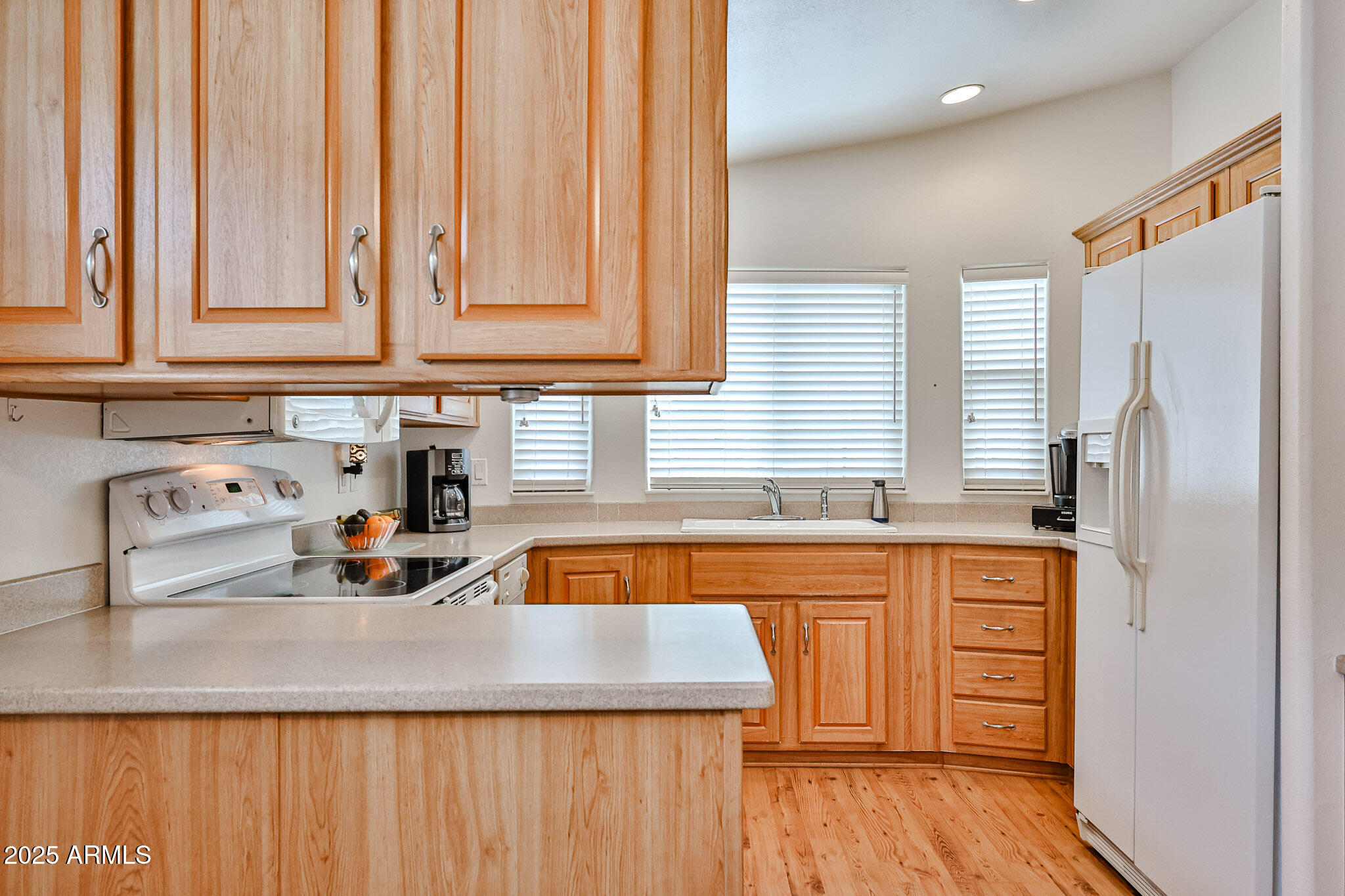17200 West Bell Road, Unit 1185 Surprise, AZ 85374 - Photo 6 of 44 a kitchen with stainless steel appliances granite countertop a sink and a wooden cabinets