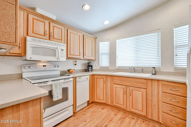 a kitchen with stainless steel appliances granite countertop a sink and cabinets with wooden floors