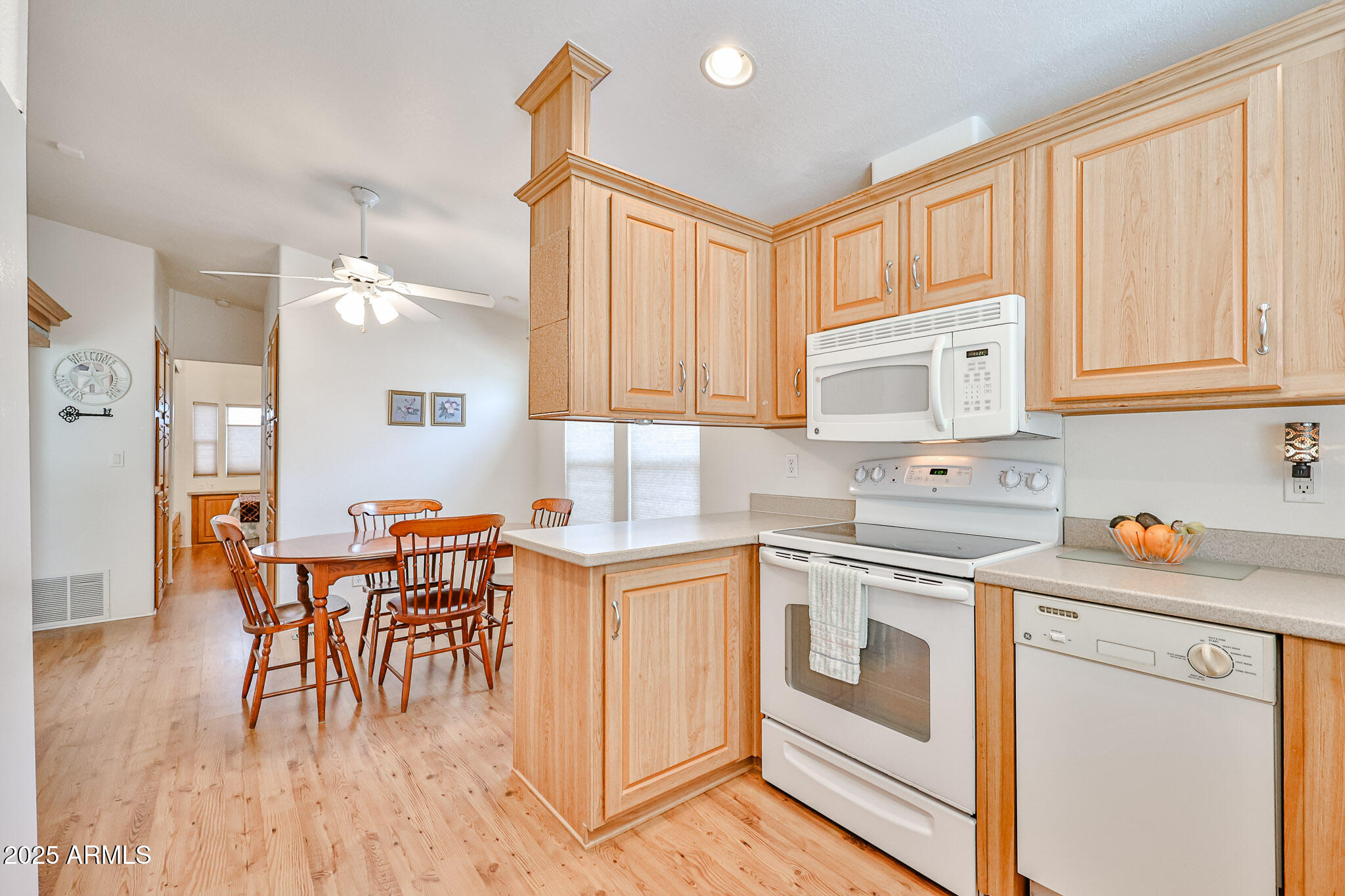 17200 West Bell Road, Unit 1185 Surprise, AZ 85374 - Photo 9 of 44 a kitchen with stainless steel appliances granite countertop a stove a sink dishwasher and white cabinets with wooden floor
