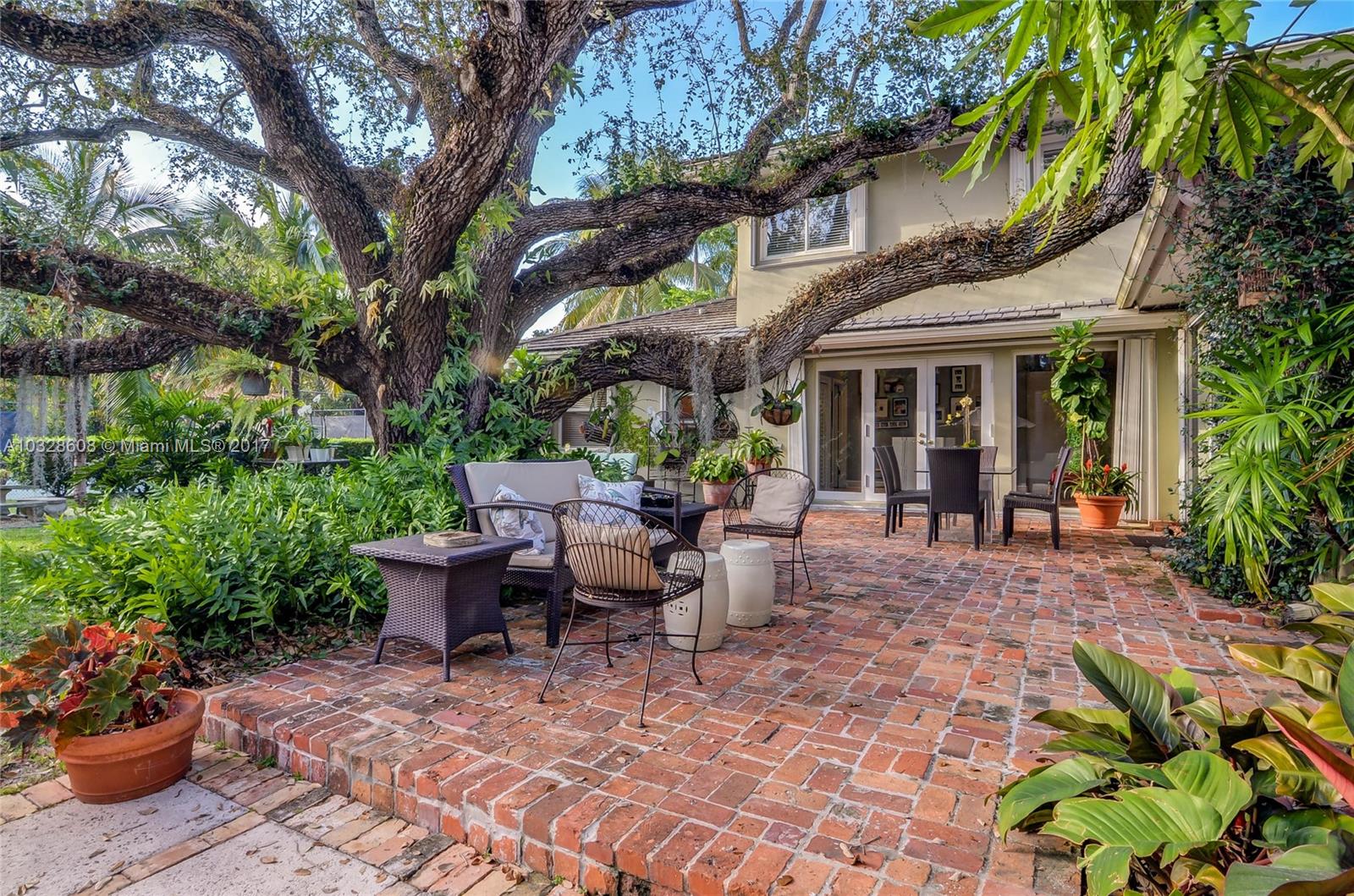 8150 Erwin Road Miami, FL 33143 - Photo 12 of 36 a view of a patio with table and chairs potted plants and large tree