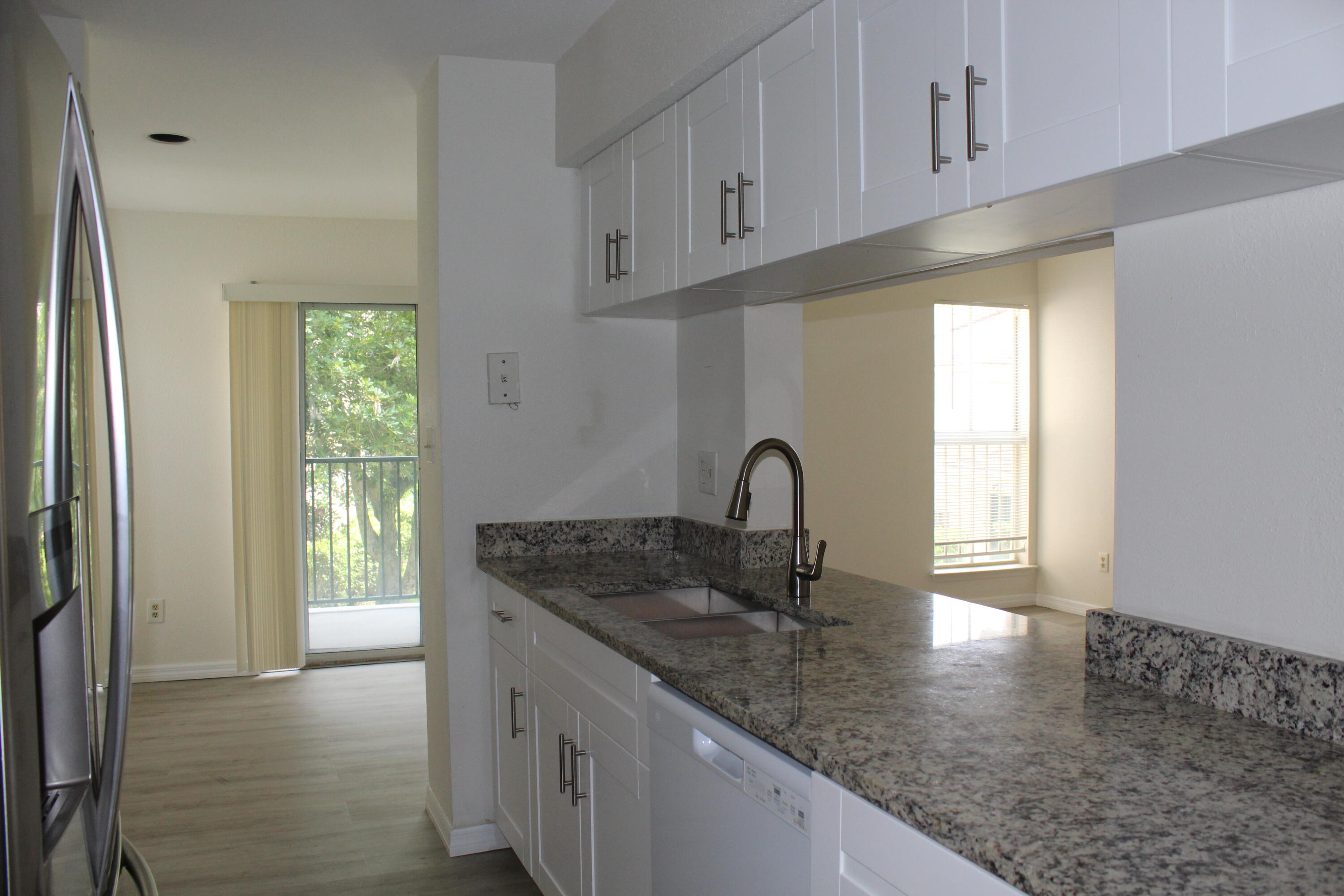 899 Riverside Drive, Unit 620 Coral Springs, FL 33071 - Photo 19 of 46 a kitchen with granite countertop a sink a window and cabinets