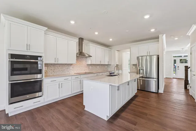 a kitchen with stainless steel appliances a stove a sink and a refrigerator