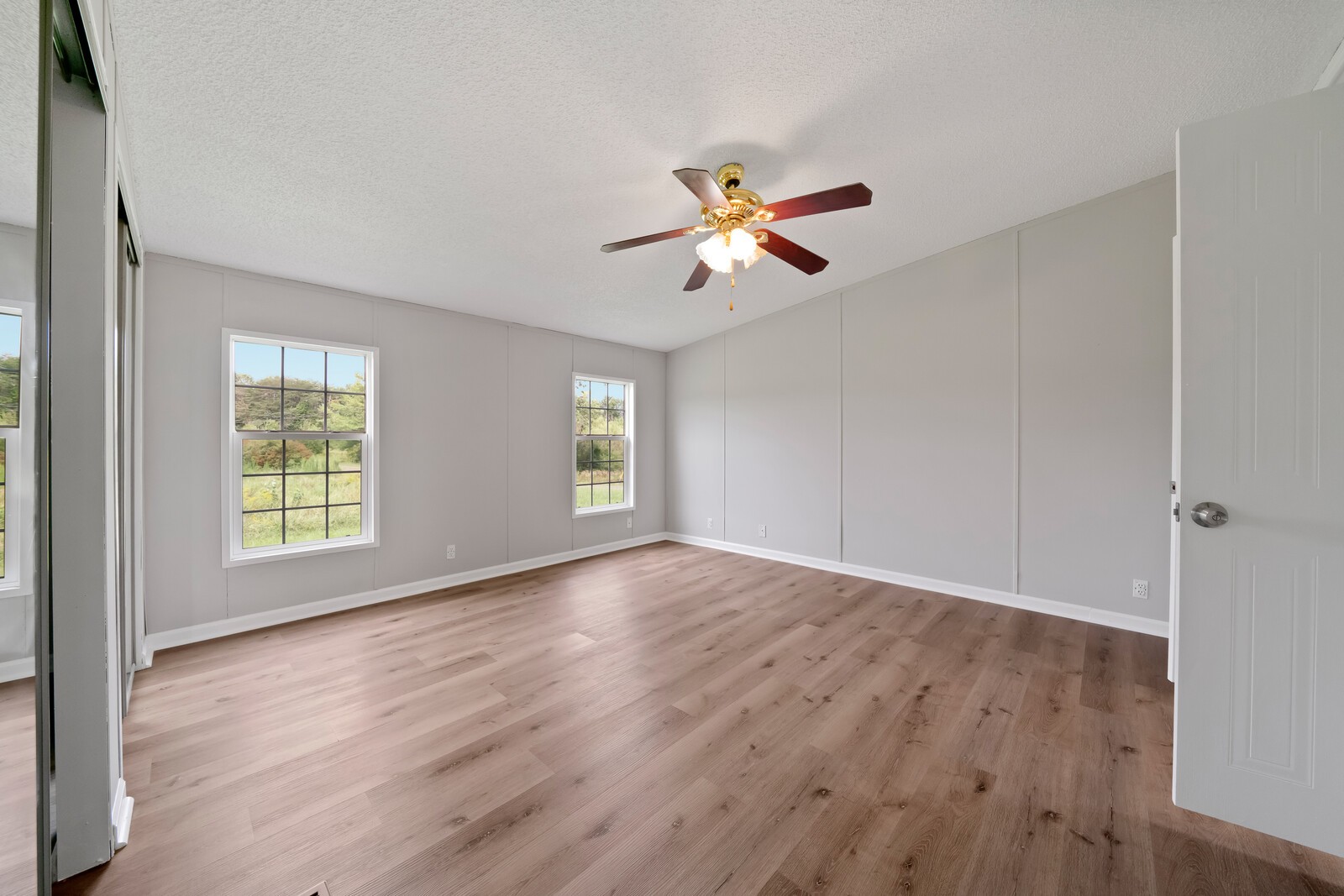 450 Obie Adcock Road Smithville, TN 37166 - Photo 15 of 30 a view of empty room with wooden floor and fan