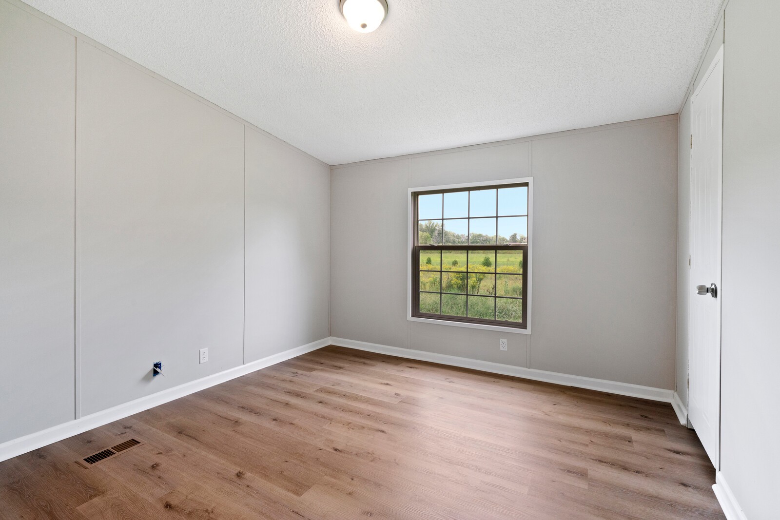 450 Obie Adcock Road Smithville, TN 37166 - Photo 21 of 30 an empty room with wooden floor and windows