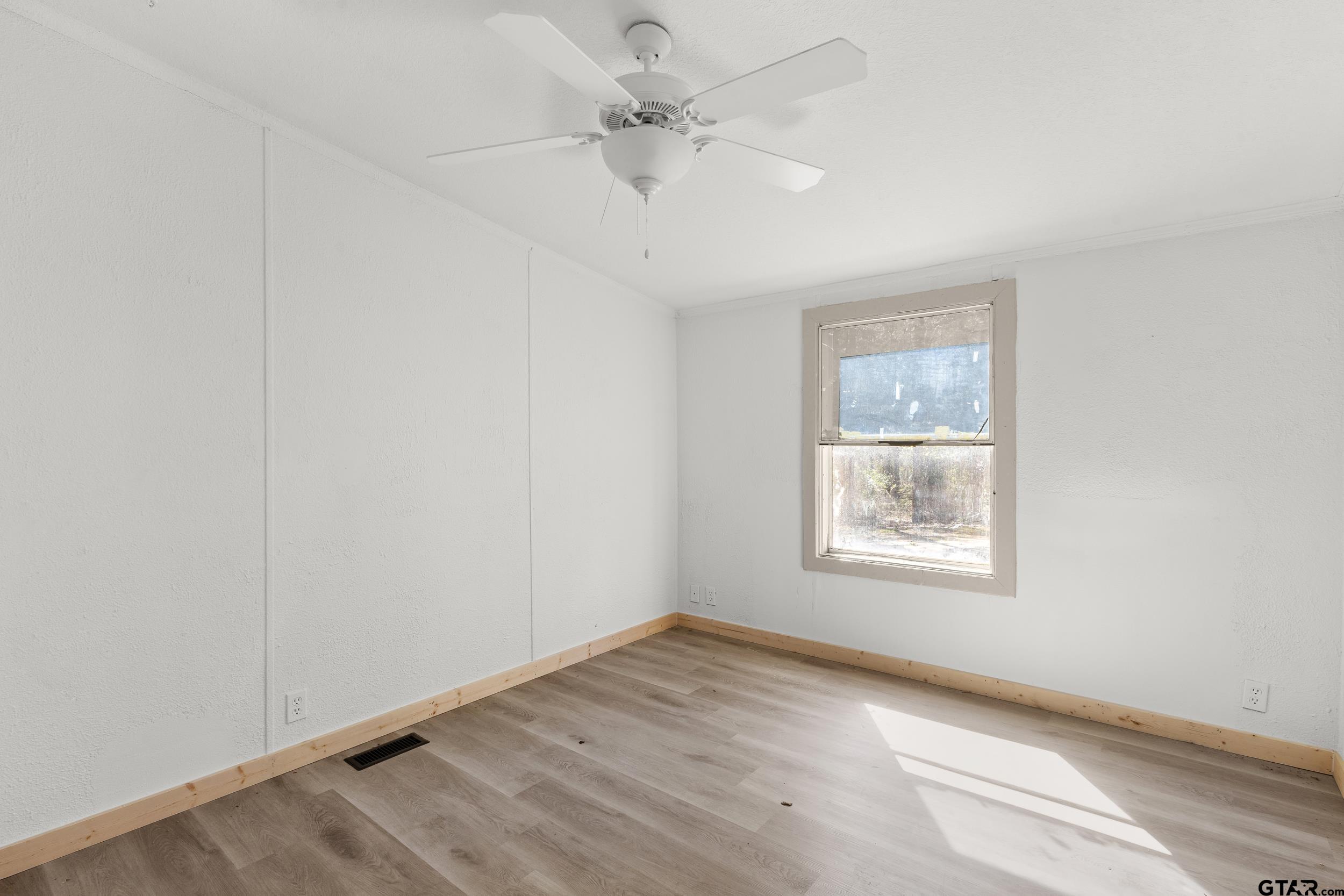 180 Southeast County Road Southeast Mount Vernon, TX 75457 - Photo 15 of 32 an empty room with a window and a ceiling fan