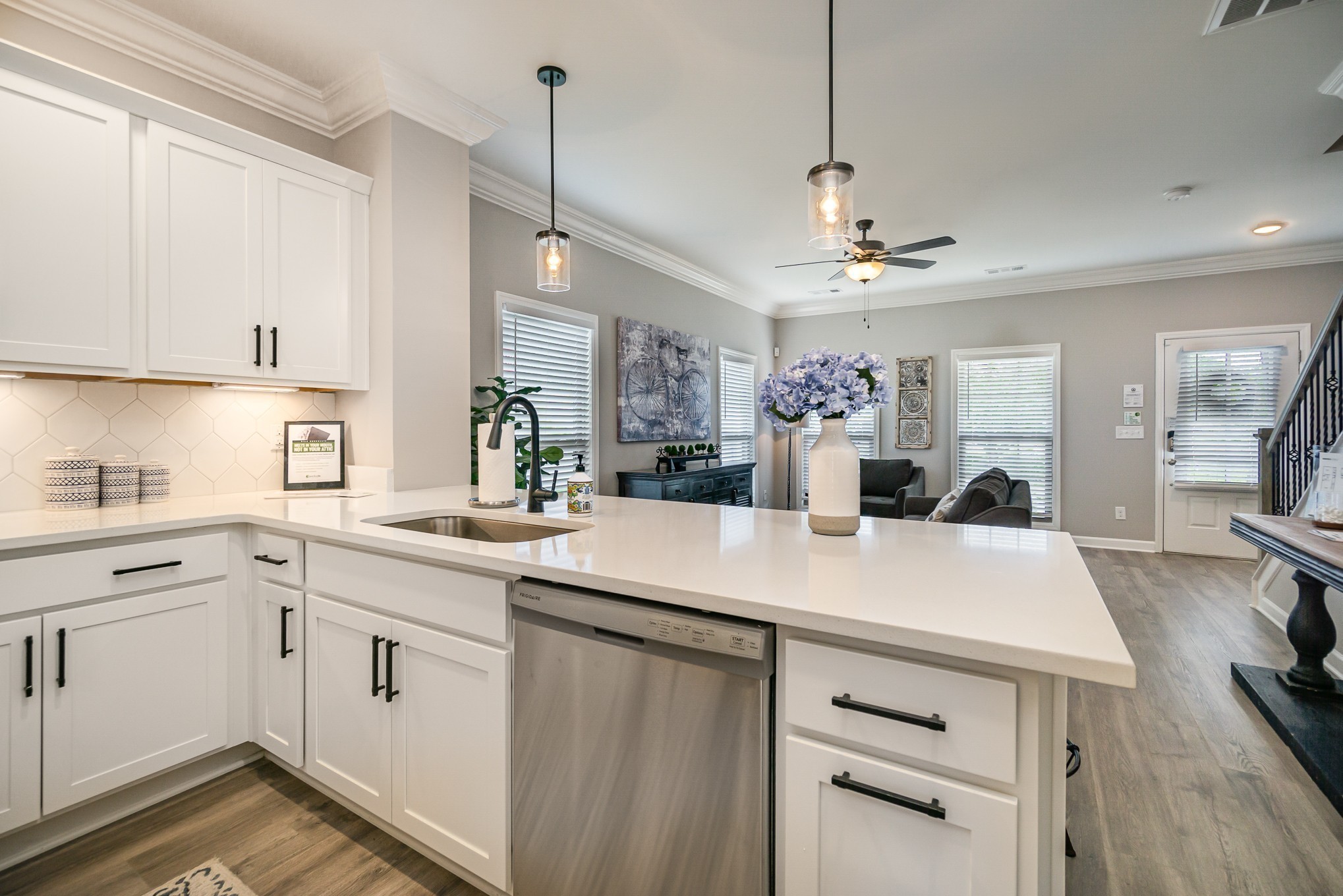 1748 Fenway Loop Antioch, TN 37013 - Photo 13 of 38 a kitchen with a sink dishwasher a stove and white cabinets with wooden floor
