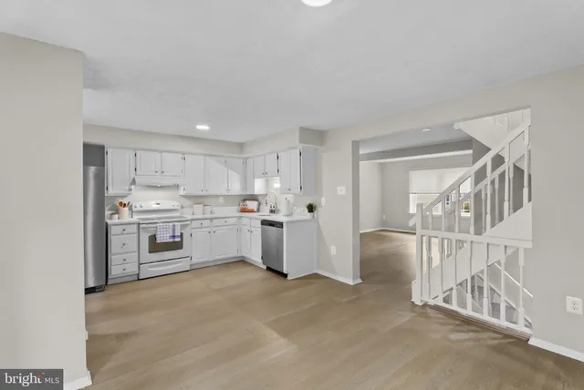 a kitchen with white cabinets and white appliances