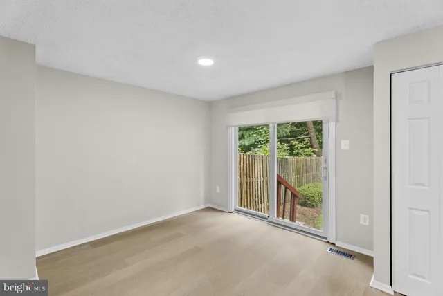 an empty room with wooden floor and a window