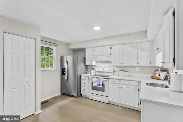 a kitchen with cabinets appliances and a window