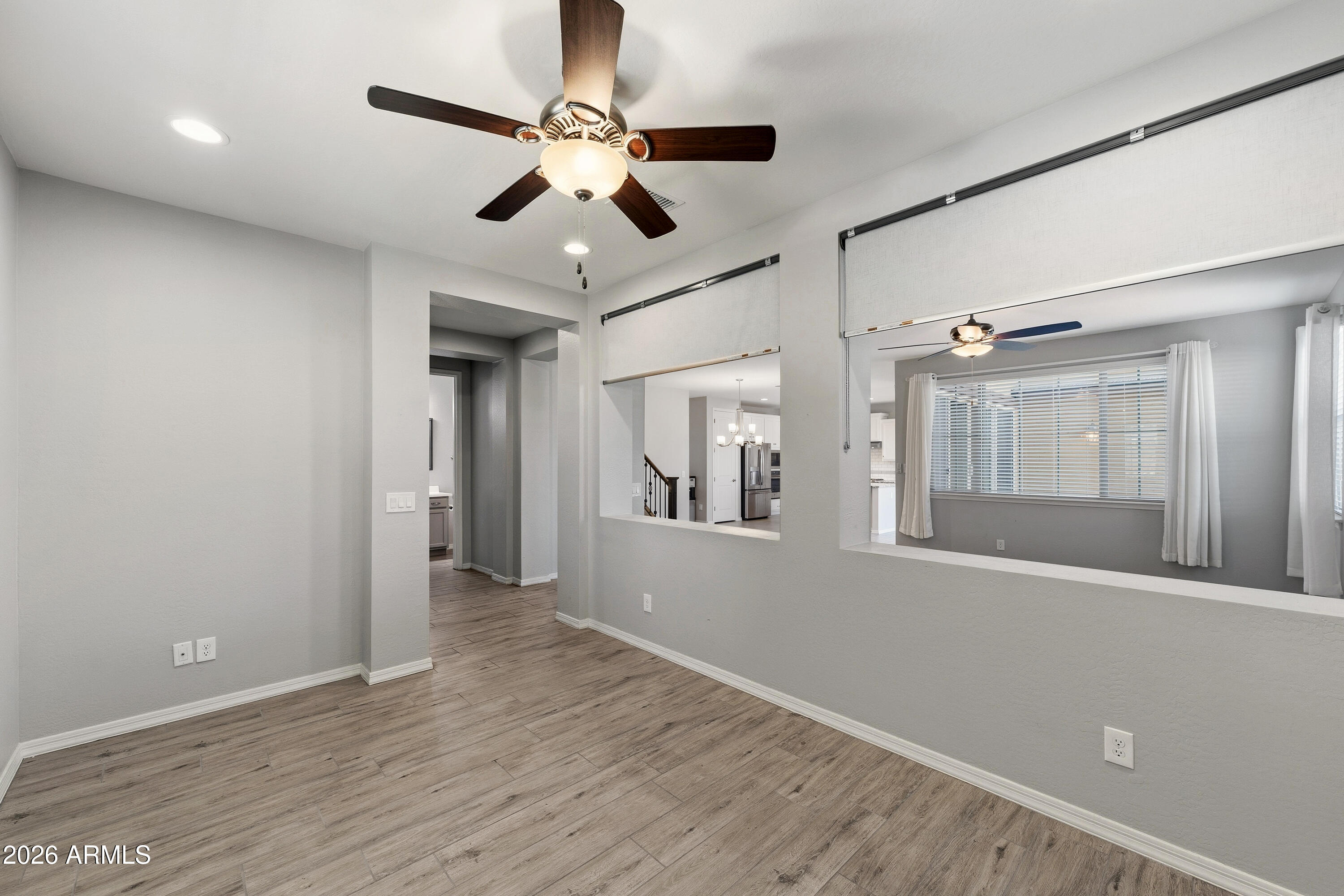 3909 East Perkinsville Street Gilbert, AZ 85295 - Photo 4 of 29 a view of an empty room with wooden floor and fan