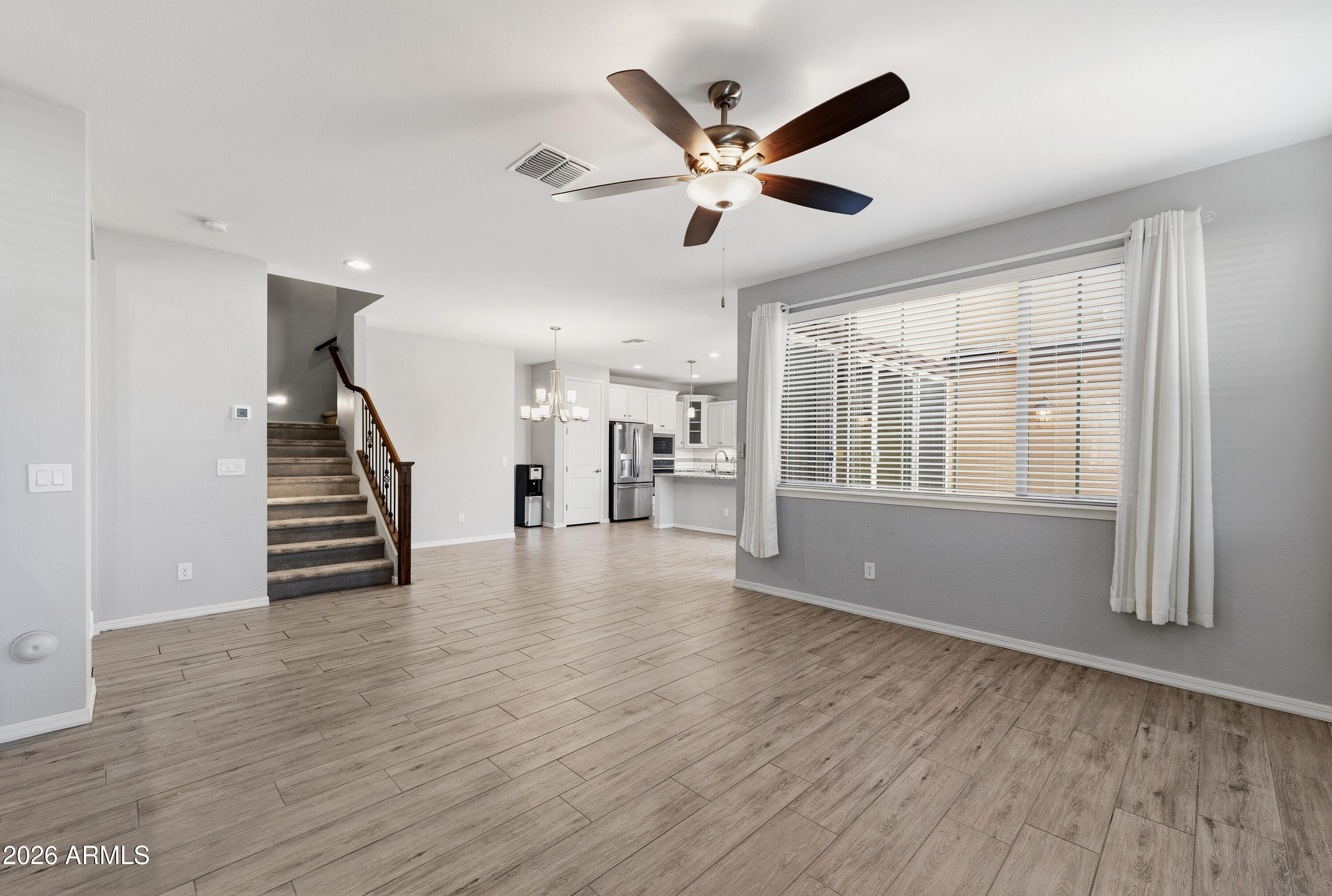 3909 East Perkinsville Street Gilbert, AZ 85295 - Photo 6 of 29 a view of a livingroom with wooden floor staircase and a kitchen