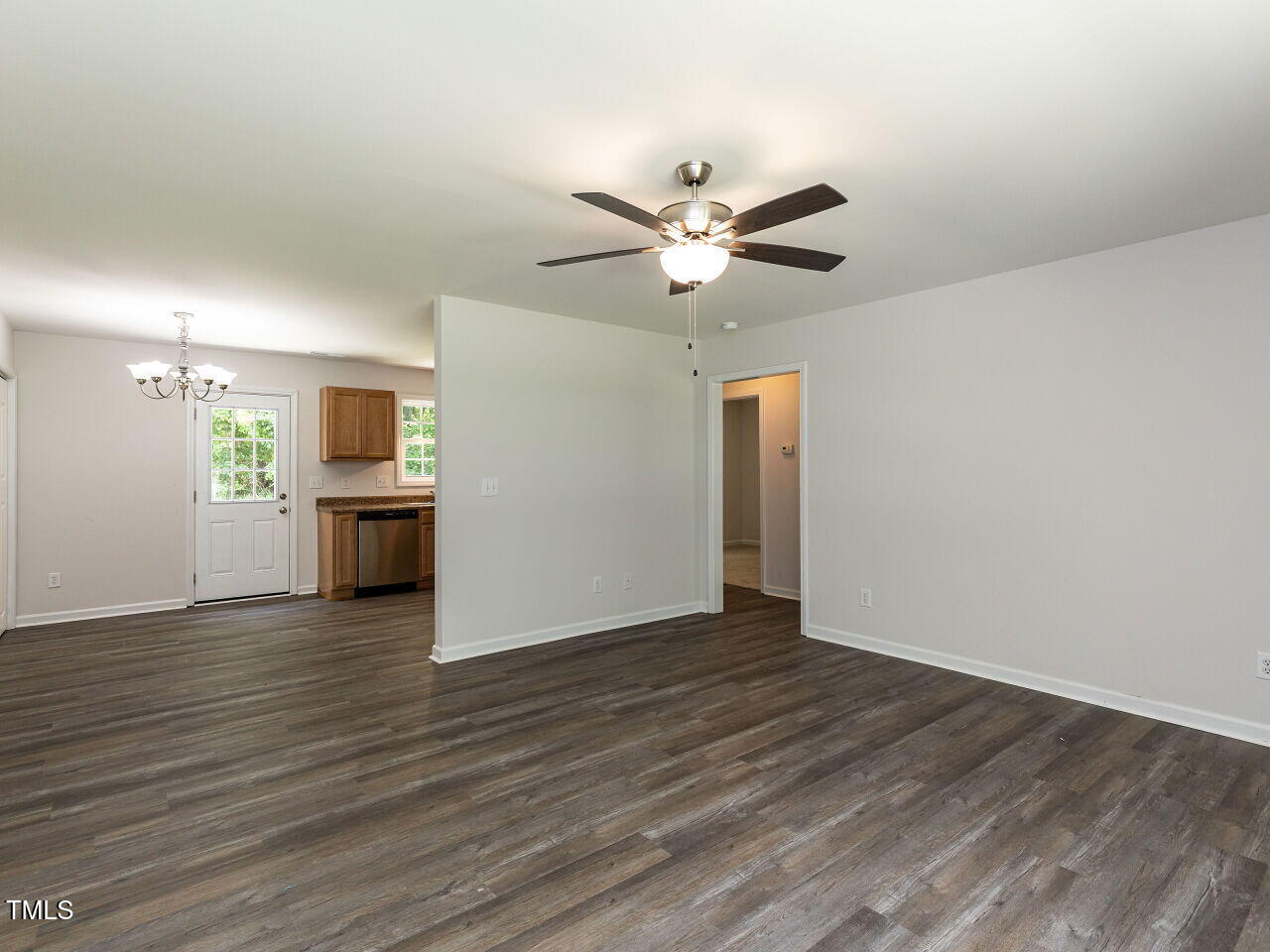 381 Gray Ghost Street Benson, NC 27504 - Photo 14 of 33 a view of an empty room with wooden floor and a kitchen