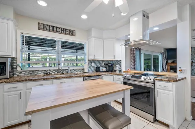 a kitchen with stainless steel appliances granite countertop a refrigerator and a stove top oven
