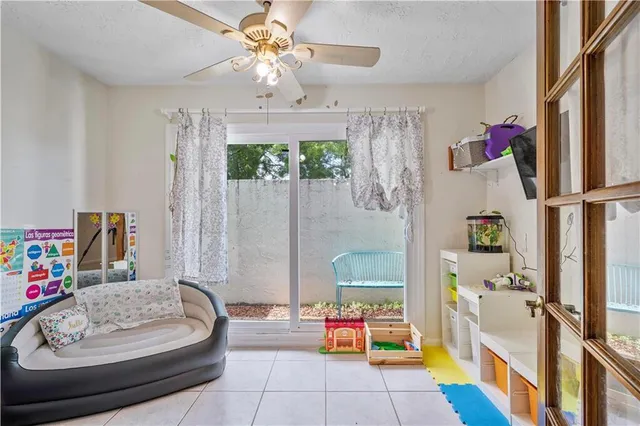 a view of a white house with a big yard and potted plants and large trees