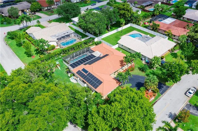 a view of yellow house with palm trees