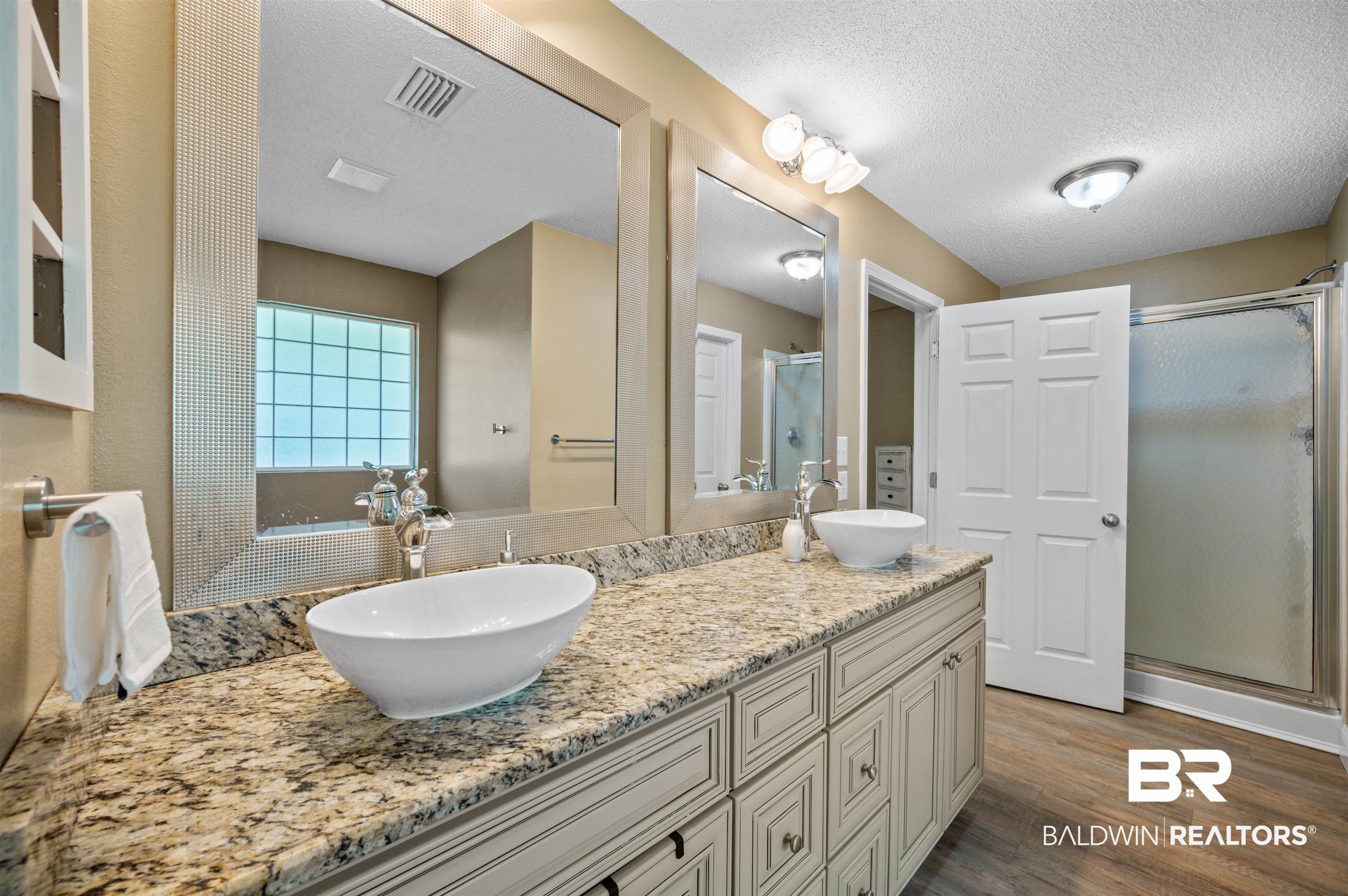 11705 Venice Boulevard Foley, AL 36535 - Photo 25 of 43 Bathroom featuring wood-type flooring, an enclosed shower, a textured ceiling, and dual bowl vanity