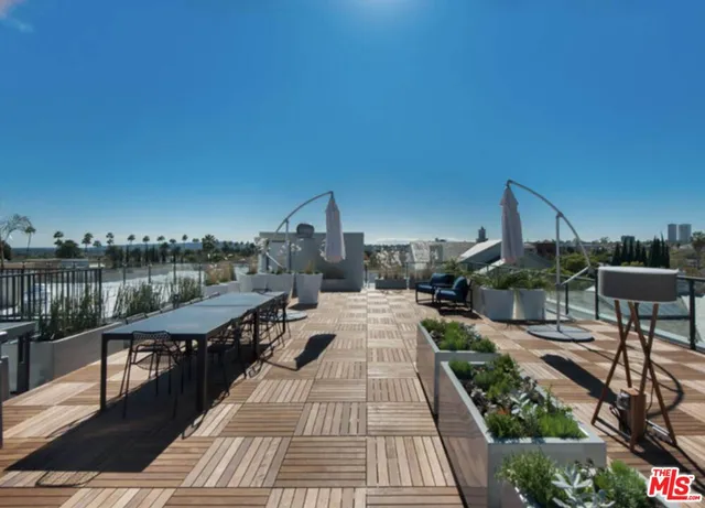 a view of a balcony with wooden floor and outdoor seating