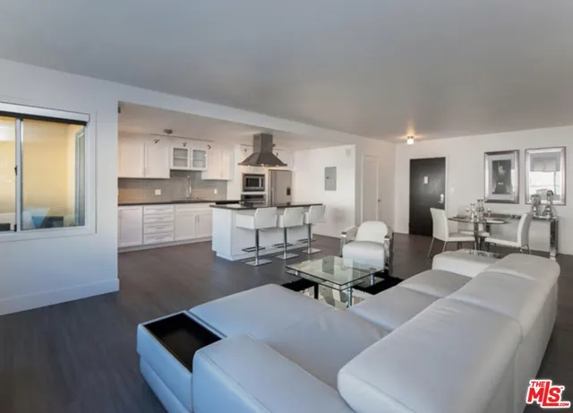 a living room with furniture and view of kitchen