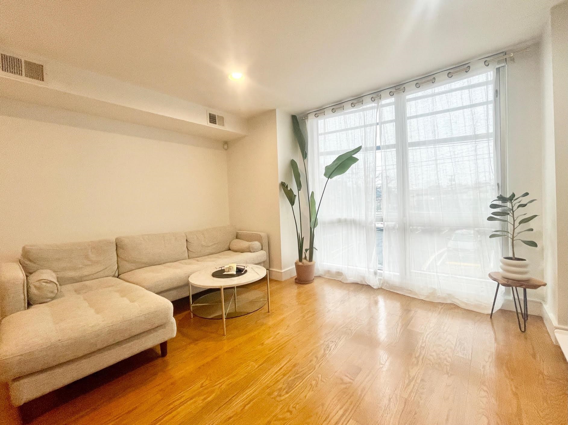8917 Old River Road, Unit 5 Edgewater, NJ 07047 - Photo 2 of 7 a living room with furniture and a large window