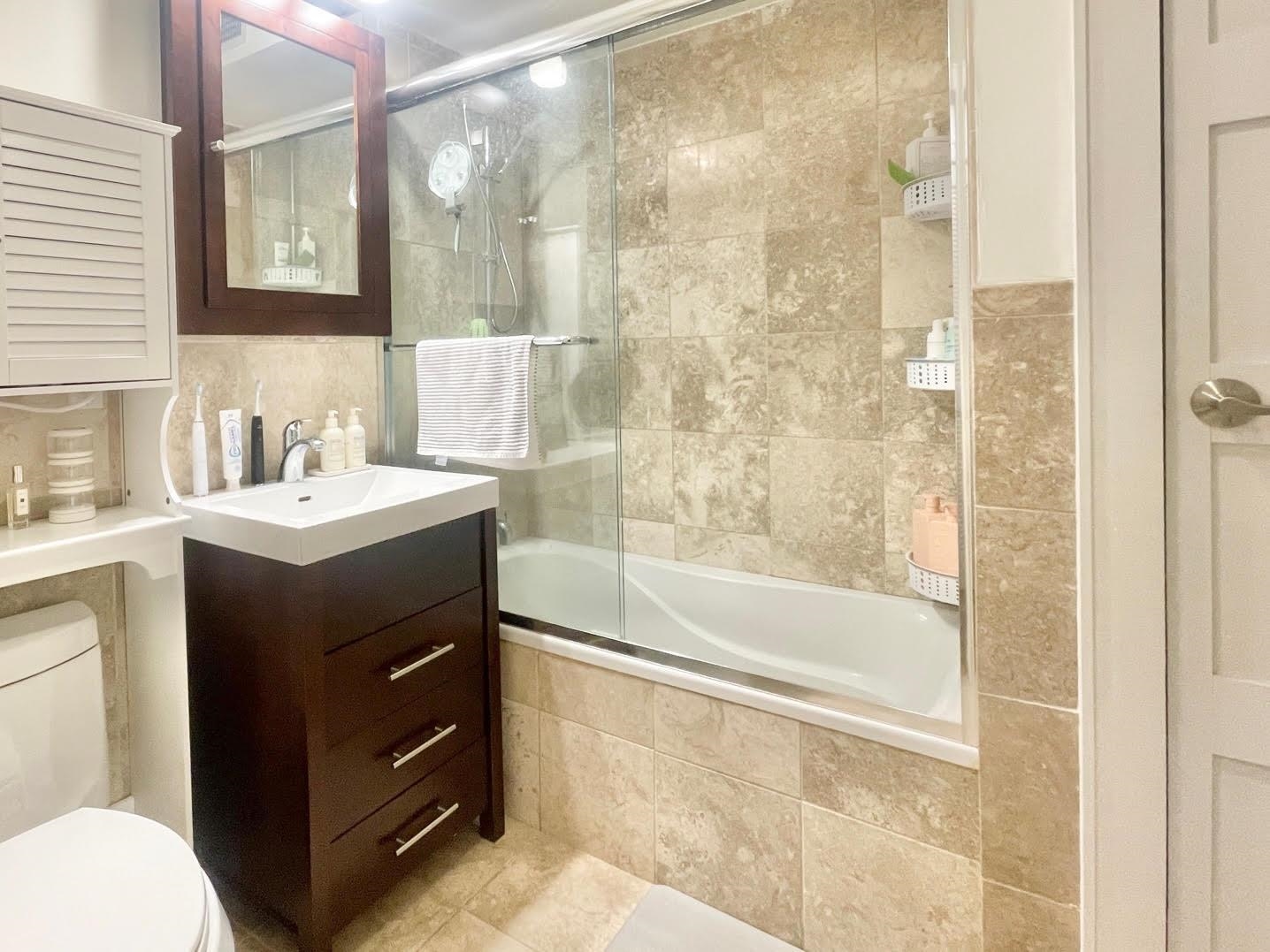 8917 Old River Road, Unit 5 Edgewater, NJ 07047 - Photo 4 of 7 a bathroom with a sink vanity mirror and a bathtub