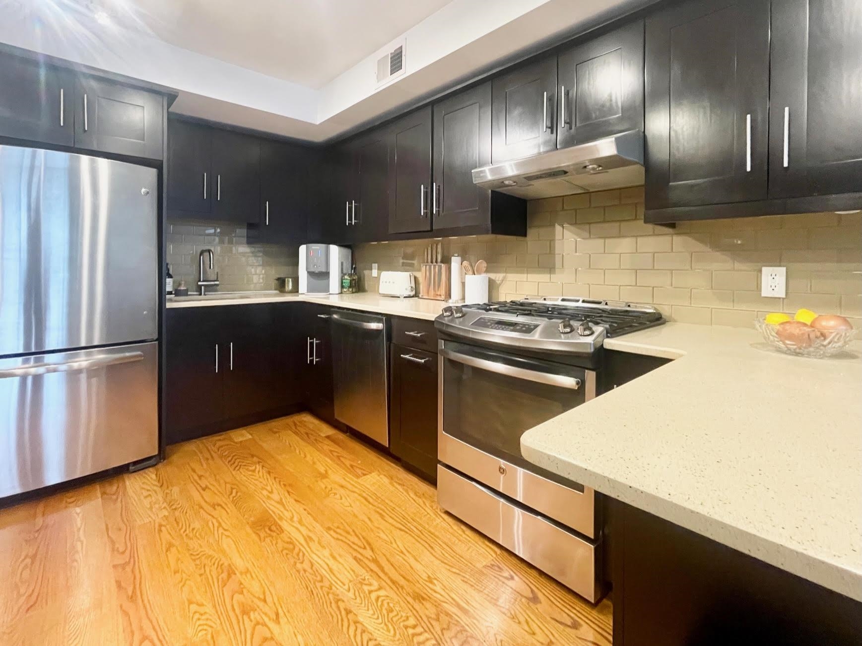 8917 Old River Road, Unit 5 Edgewater, NJ 07047 - Photo 6 of 7 a kitchen with stainless steel appliances granite countertop a sink a stove and refrigerator