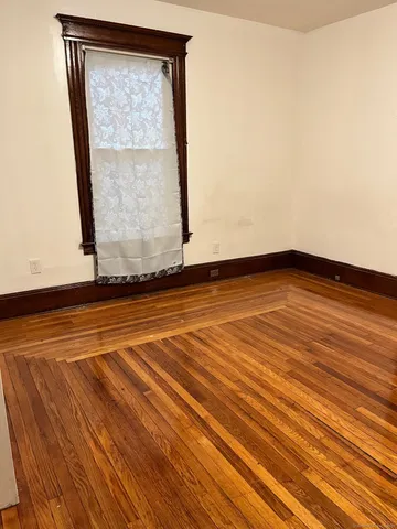 a view of a room with wooden floor and white walls