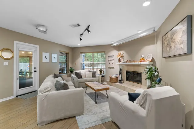 a living room with furniture a fireplace and a large window