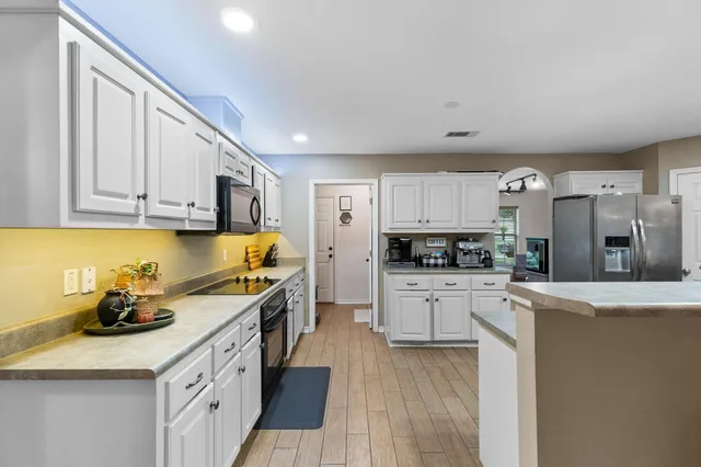 a kitchen with stainless steel appliances a stove a sink a refrigerator and cabinets