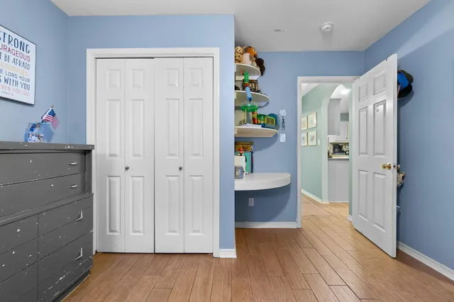 a view of hallway with window and wooden floor