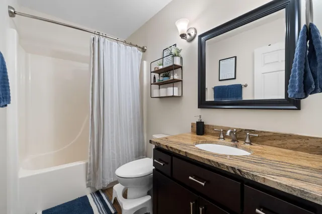 a bathroom with a granite countertop sink toilet and shower