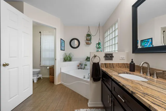a bathroom with a double vanity sink a mirror and a bathtub