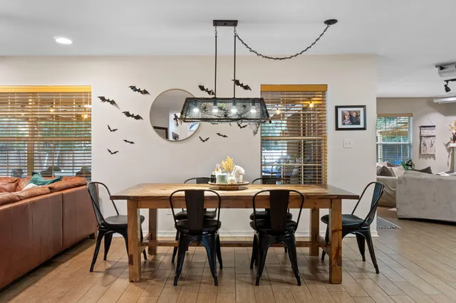 a dining room with furniture a chandelier and wooden floor