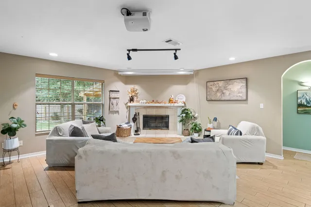 a living room with furniture a fireplace and a floor to ceiling window