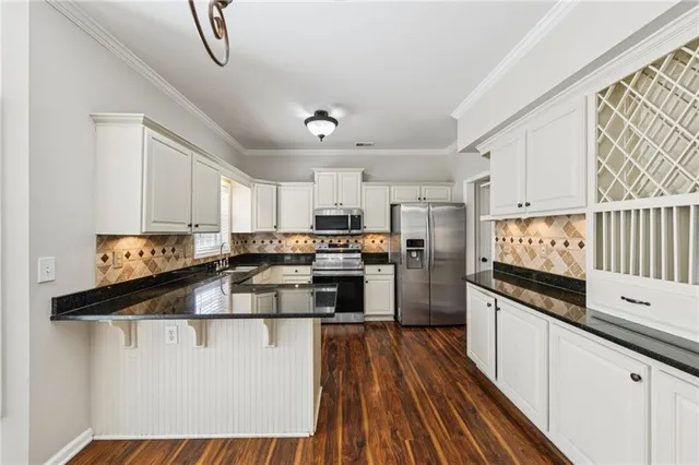 a kitchen with stainless steel appliances granite countertop a sink and cabinets