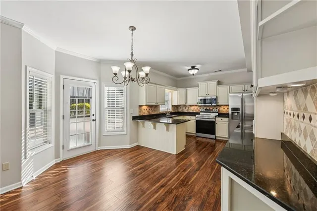 a kitchen with granite countertop stainless steel appliances and white cabinets