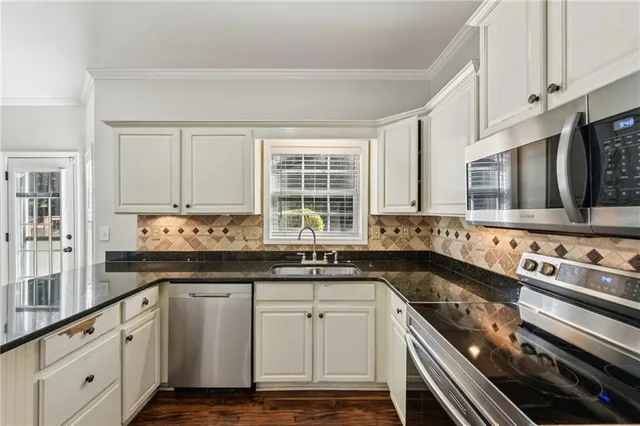 a kitchen with granite countertop a sink cabinets and wooden floor