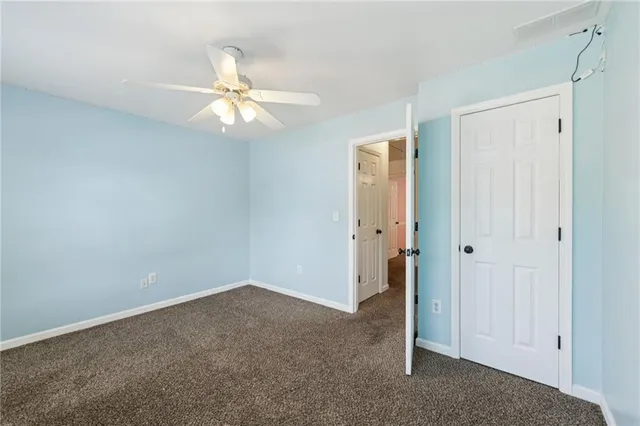 an empty room with a ceiling fan and a window