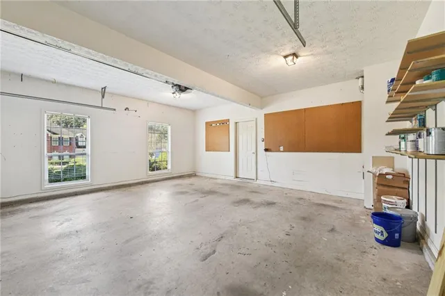 a aerial view of a house next to a yard with plants and large trees