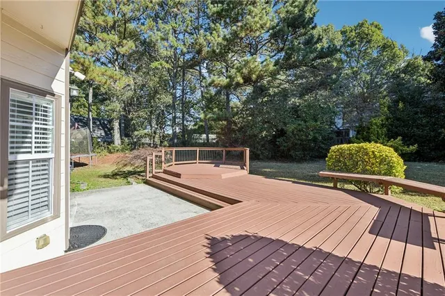 a view of a house with a small yard and large tree