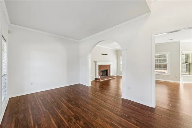 a view of empty room with wooden floor and fireplace