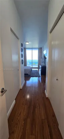 a view of a hallway with wooden floor and stairs