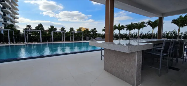 a view of a swimming pool with outdoor seating and plants