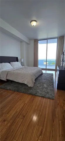 a bedroom with a bed and large window