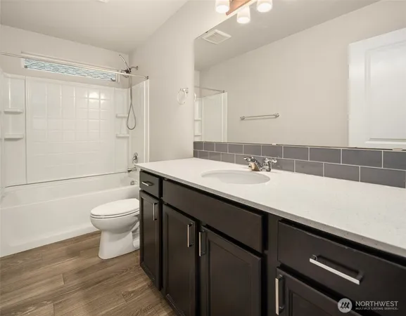 a bathroom with a sink a toilet a shower and a mirror