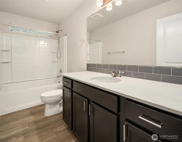 a bathroom with a sink a toilet a shower and a mirror